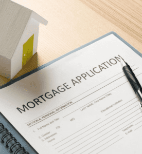 Mortgage application document with little wooden house model