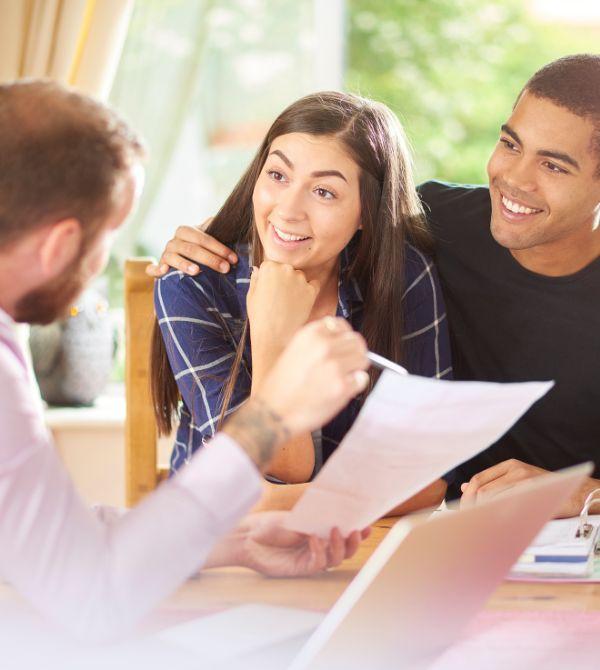 Mortgage lender explaining loan document to couple