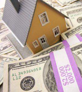 Model of a home on a pile of money