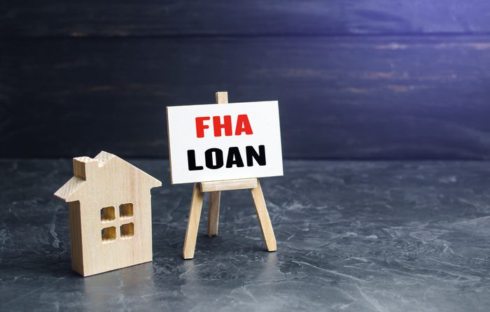 Small house and FHA loan easel sign. Mortgage insured by Federal Housing Administration Loan.
