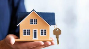 House model and key in home mortgage broker agent hand