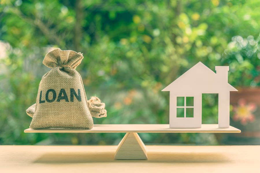 House model, loan bag on basic balance scale, depicts saving for a house or flat manageable and turn a home buying dream into reality