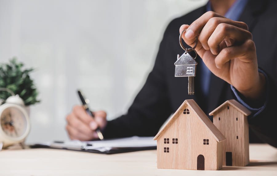 Business hand holding home - refinancing concept