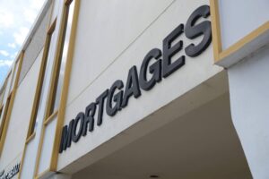 Business cards for Ace Mortgage Loan Corporation on a desk, highlighting mortgage brokerage services